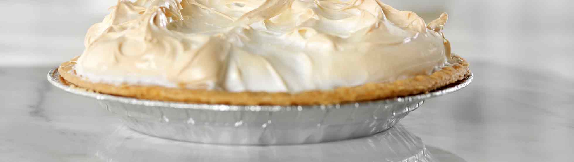 A single pie in a foil container rests on a marble countertop